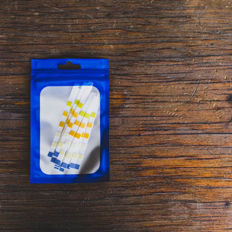 A blue pouch of pool test strips on a wooden table.